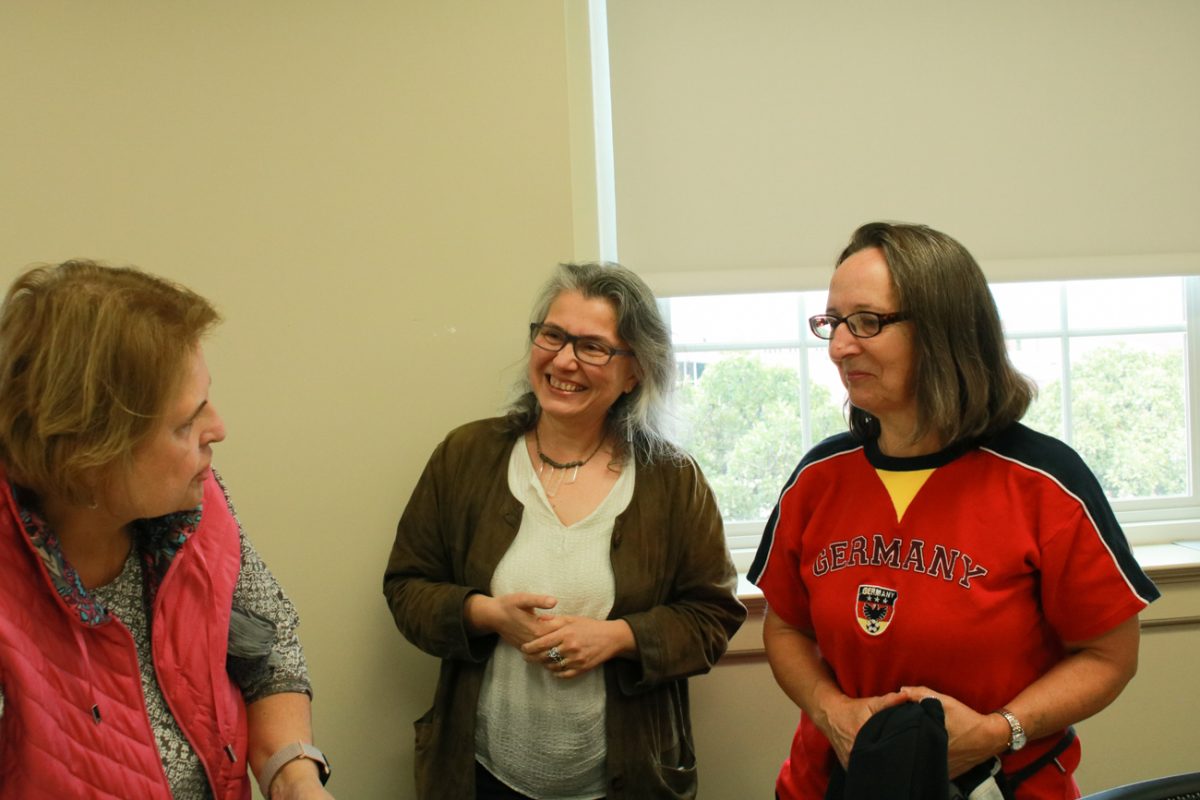Refika Sarıönder Kreinath, a Wichita State lecturer in German, smiles while speaking with community members Christa Wallin (left) and Christa Nelson (right). Kreinath organized the Oktoberfest gathering on Oct. 6.