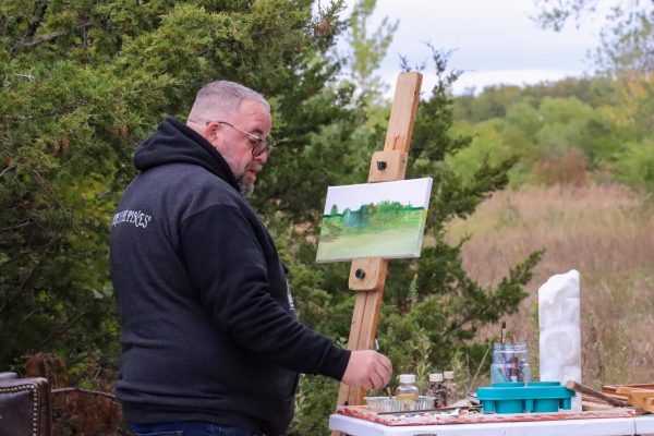 Jeremy Alessi, former member of the Wichita Arts Council, paints at Art On the Trail at Great Plains Nature Center on Saturday. The event hosted a range of artists at wine tasting. Alessi is also a sculptor and used to be a professional photographer.