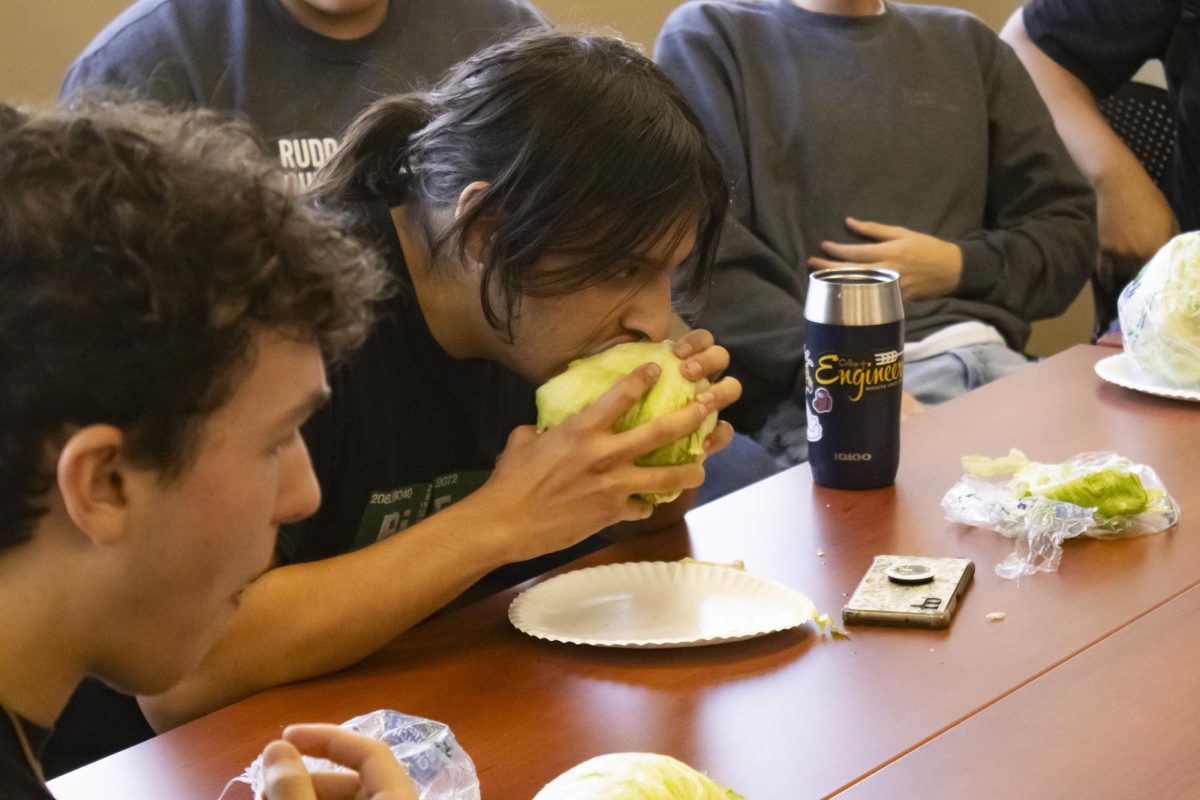 Noah Sanford begins eating his lettuce head at the second lettuce head eating competition held by Green Group on Oct. 11.