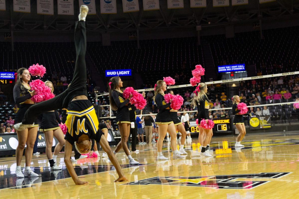 Zarek Burkert tumbles during a break at a volleyball game on Oct. 20. The Wichita State cheer team honored Breast Cancer Awareness Month with pink pom poms and hairbows.