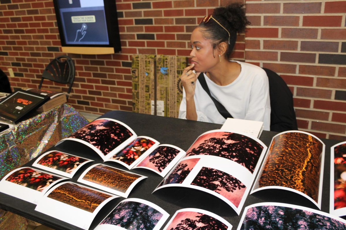 Makenna Green sells photograph prints at Art Market in the RSC. The school of Art, Design and Creative Industries (ADCI) held a student-led Art Market on Nov. 29 and 30 to showcase various artists from the College of Fine Arts and give them experience selling their work.