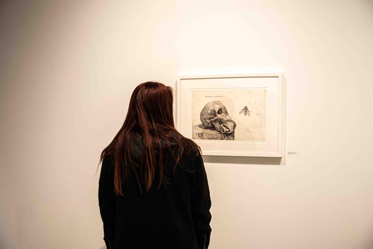 A woman looks at a piece of art in the Art Exhibition at McKnight Art Center on Nov. 17.
