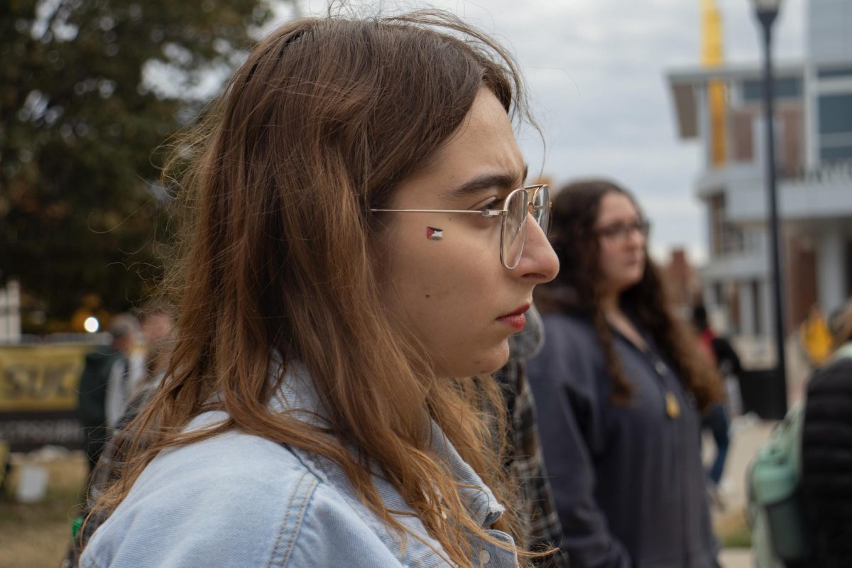 Kendah Ballout listens as the names of 220 killed Palestinans are read during the Arab Student Associations vigil for lost Palestinian lives on Nov. 9. Kendah, along with some of her friends, painted the Palestinian flag on their cheeks before the vigil.