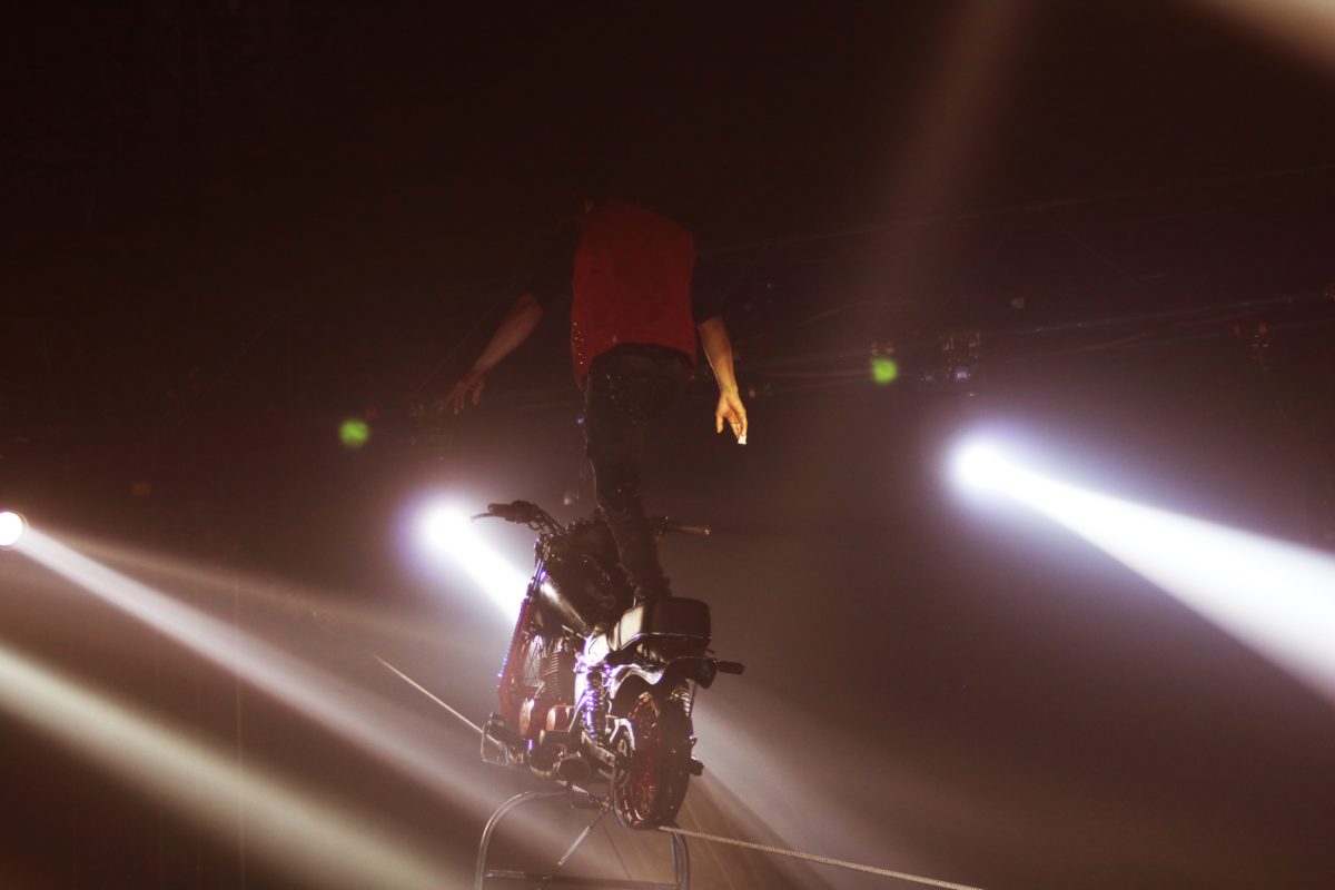 A performer stands atop a suspended motorcycle during the Paranormal Cirque on Nov. 12. The Paranormal Cirque held eight different shows while in Wichita. 
