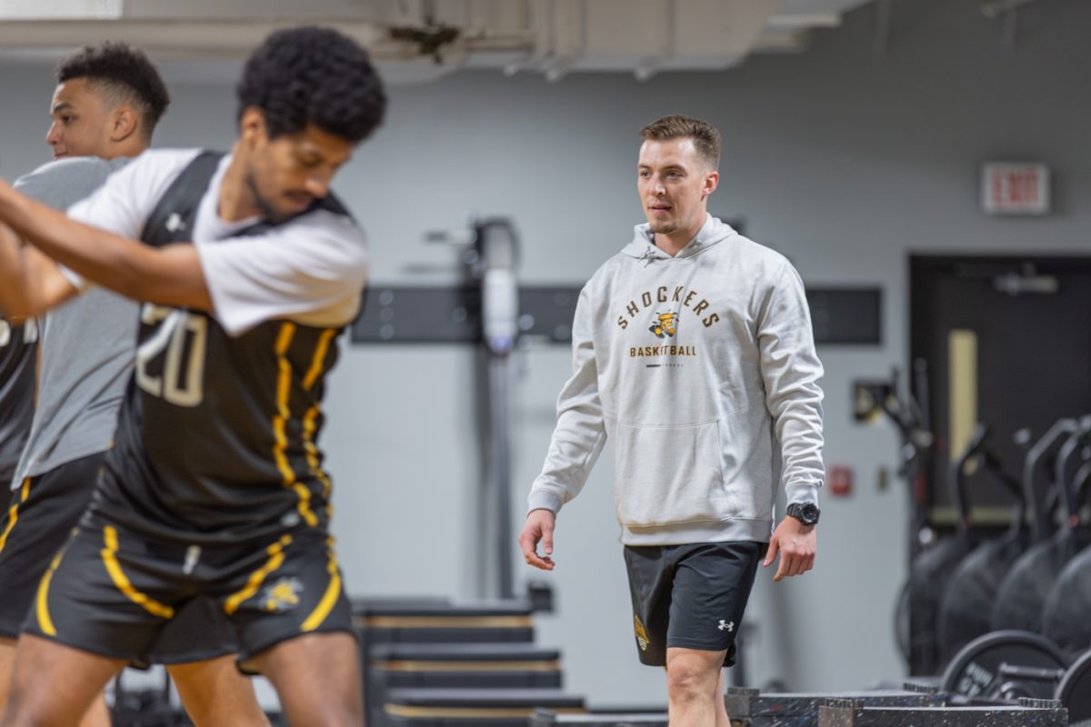 Ashtin Meerpohl, director of sports performance for the Wichita State men’s basketball team, works with players in the weight room inside Charles Koch Arena. 