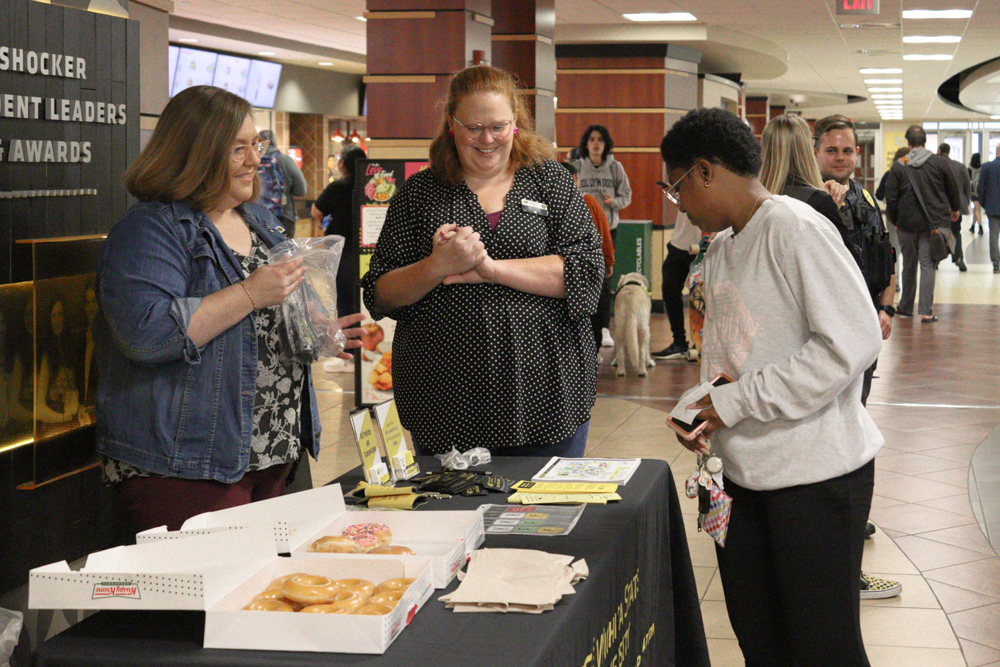 Emily Martin and Laura Ryman, who both work in Parking Services, talk to a Wichita State student during an event that encouraged community members to interact with WSUPD officers, dispatchers and Parking Services personnel on Nov. 8.