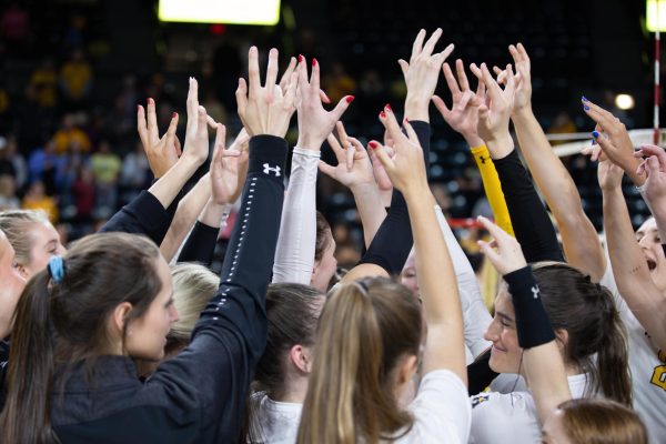 The Wichita State Volleyball team puts the WSU hand sign into the air to celebrate their win versus Drake University that put them into the Fab Four of the NIVT on December 6.