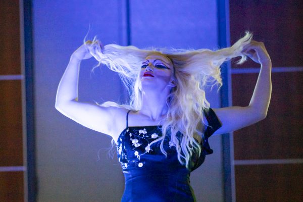 Aria Hymn throws her hair behind her back during her first performance of the night. Hymn was one of four performers for Spectrum: LGBTQ & Allies event on Dec. 9.