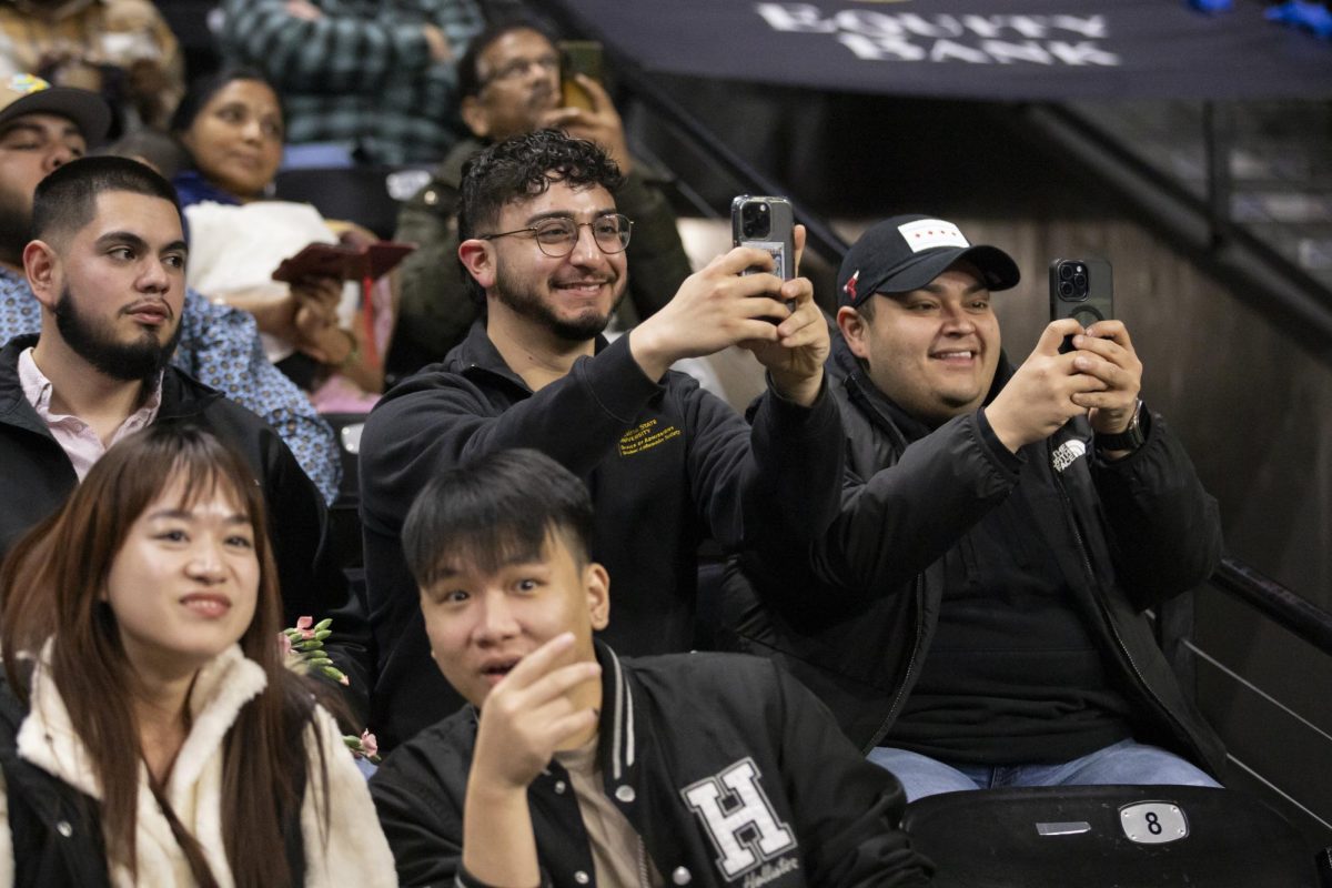 Friends of fall 2023 graduates laugh and take pictures of their friends during the Fall 2023 Commencement ceremony on Dec. 17.