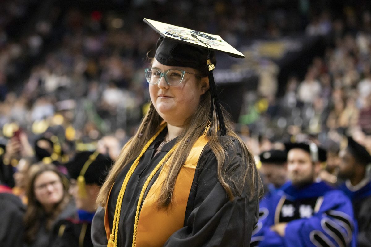 Madison (Maddie) Fields, a fall 2023 graduate, waits to have her picture taken before walking across the stage in Charles Koch Arena. Fields was the first student at Wichita State University to graduate with a bachelors degree in American Sign Language.