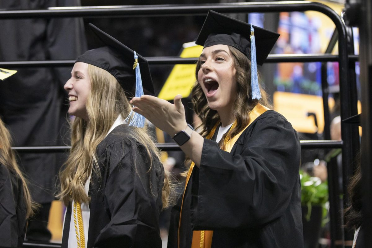 Fall 2023 graduates laugh and blow a kiss to family and friends inside Charles Koch Arena on Dec. 17.