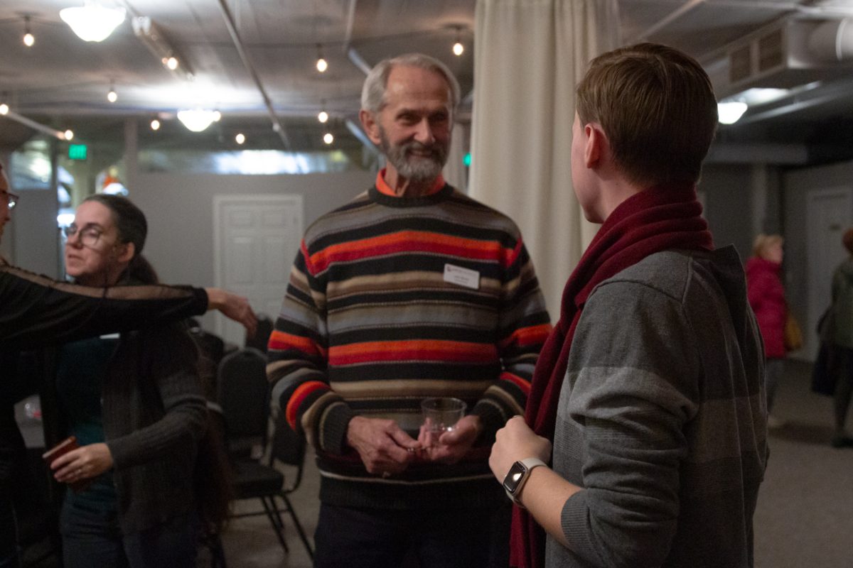 Jack Silvers and Ethan Caylor discuss art pieces at the Art Council mixer on Dec, 19. They talked about networking for Caylors candle company, E. D. Caylor.