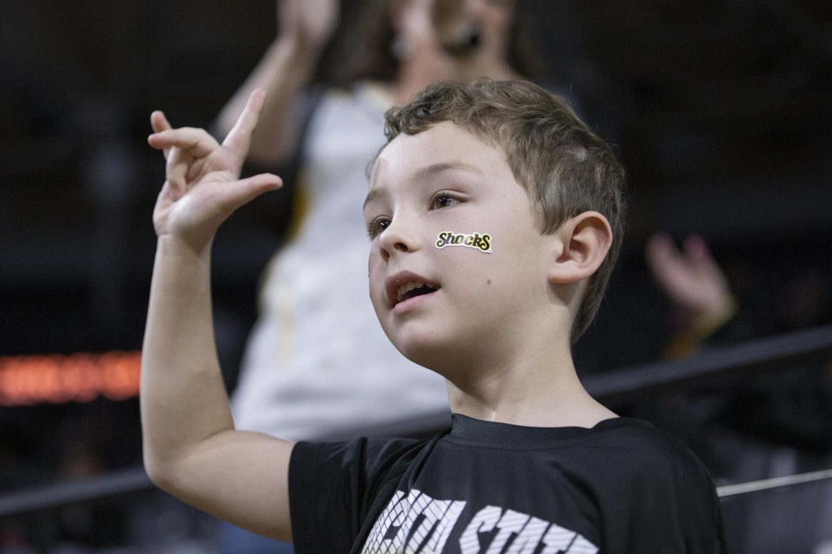 A child in Charles Koch Arena cheers on the womens basketball team during the game against Tulane University on Dec. 30.