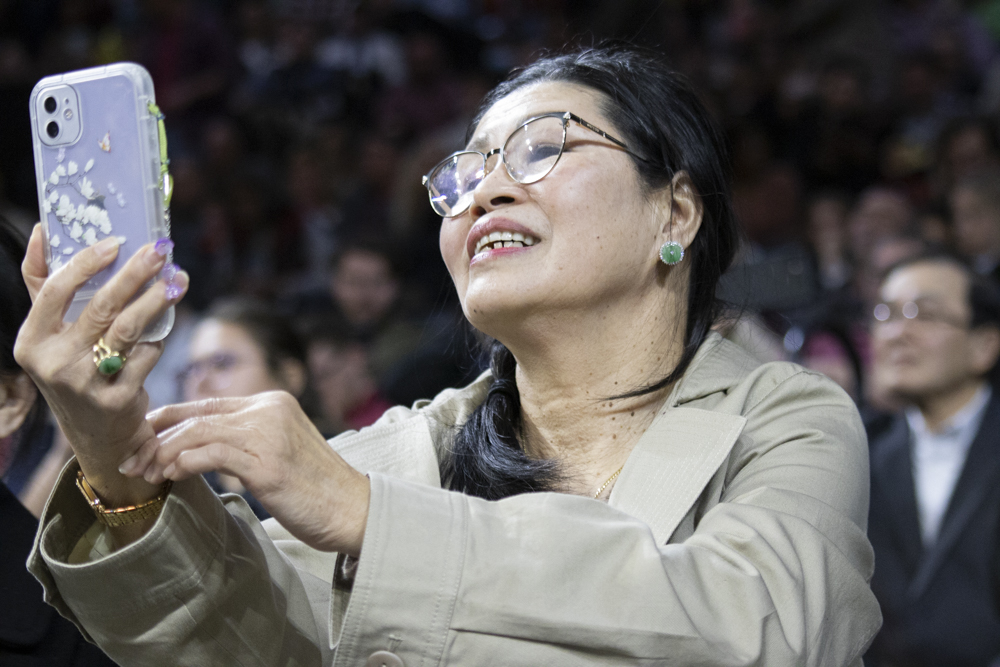 A family member takes photos of their graduate as the class of 2023 walks into the commencement ceremony on Dec. 17.