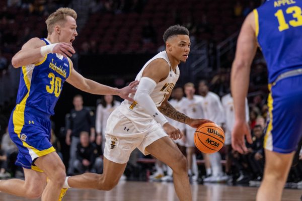 Xavier Bell runs past the South Dakota defense players during the Dec. 10 game at INTRUST Bank Arena. Bell scored 11 points and one rebound. (File Photo)