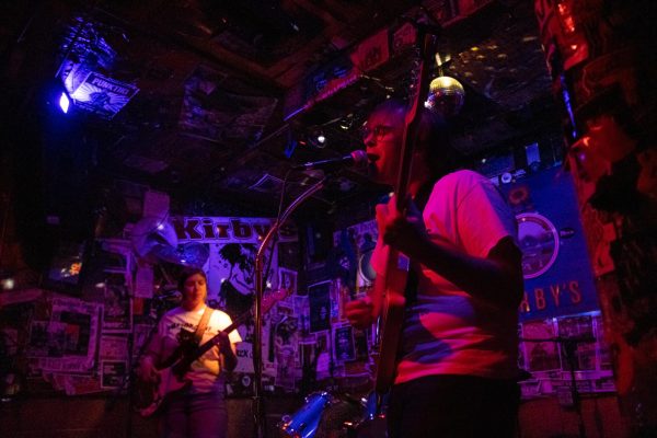 Vocalist Kyle Hall, with Emmalie Hurla behind him, perform at Kirby’s Beer Store on Jan. 13. The band describe themselves as a Midwest poet punk band.