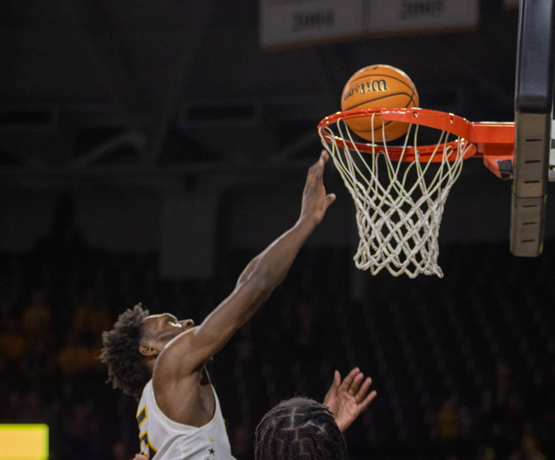 Quincy Ballard drops ball into hoop, scoring points for WSU during game on Jan. 28.