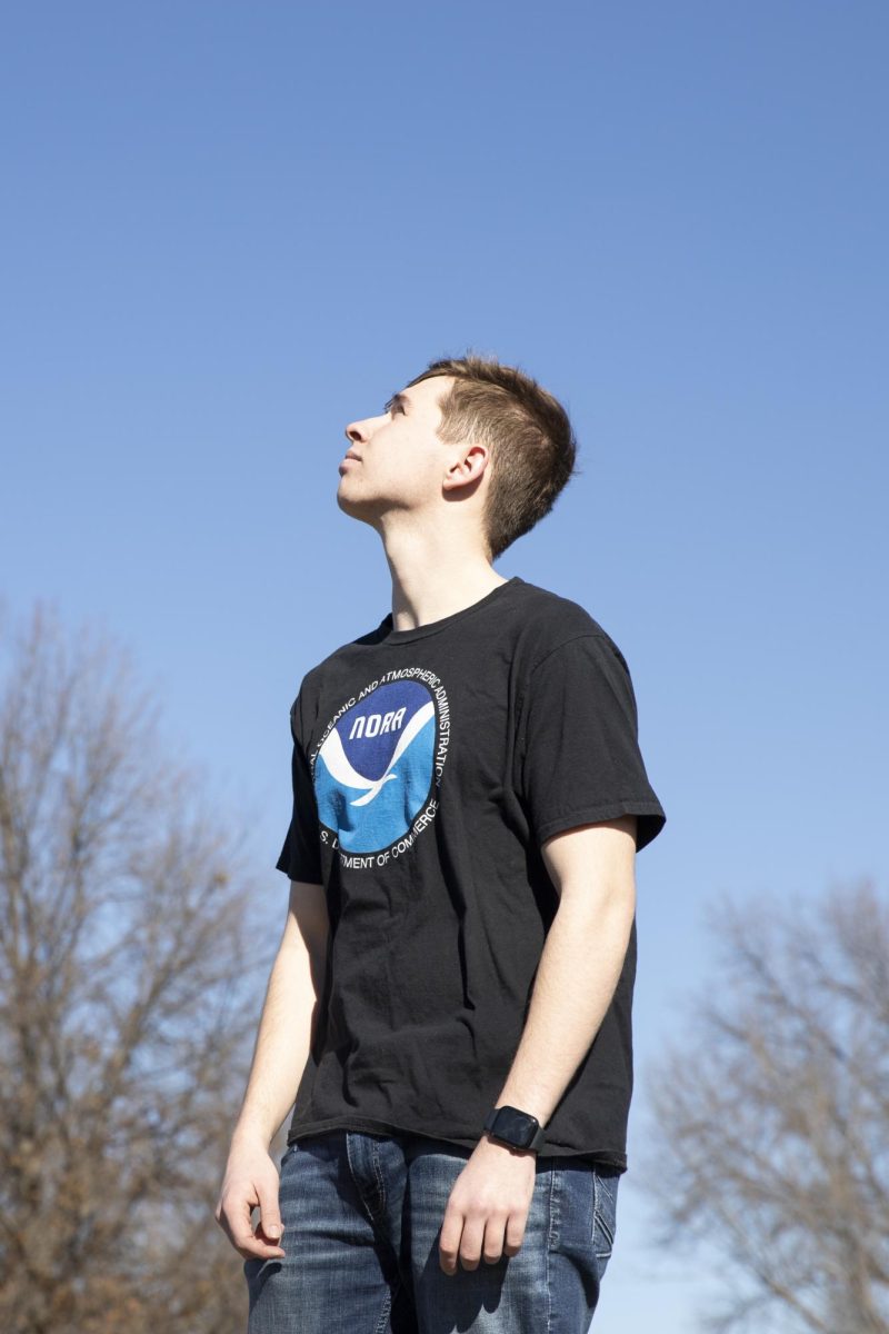 WSU Storm Trackers founding member Tristan Schwien poses for a photo while looking at the sky. Growing up in Kansas, Schwien had been interested in meteorology from a young age. He started the group to build a community with other students interested in weather.