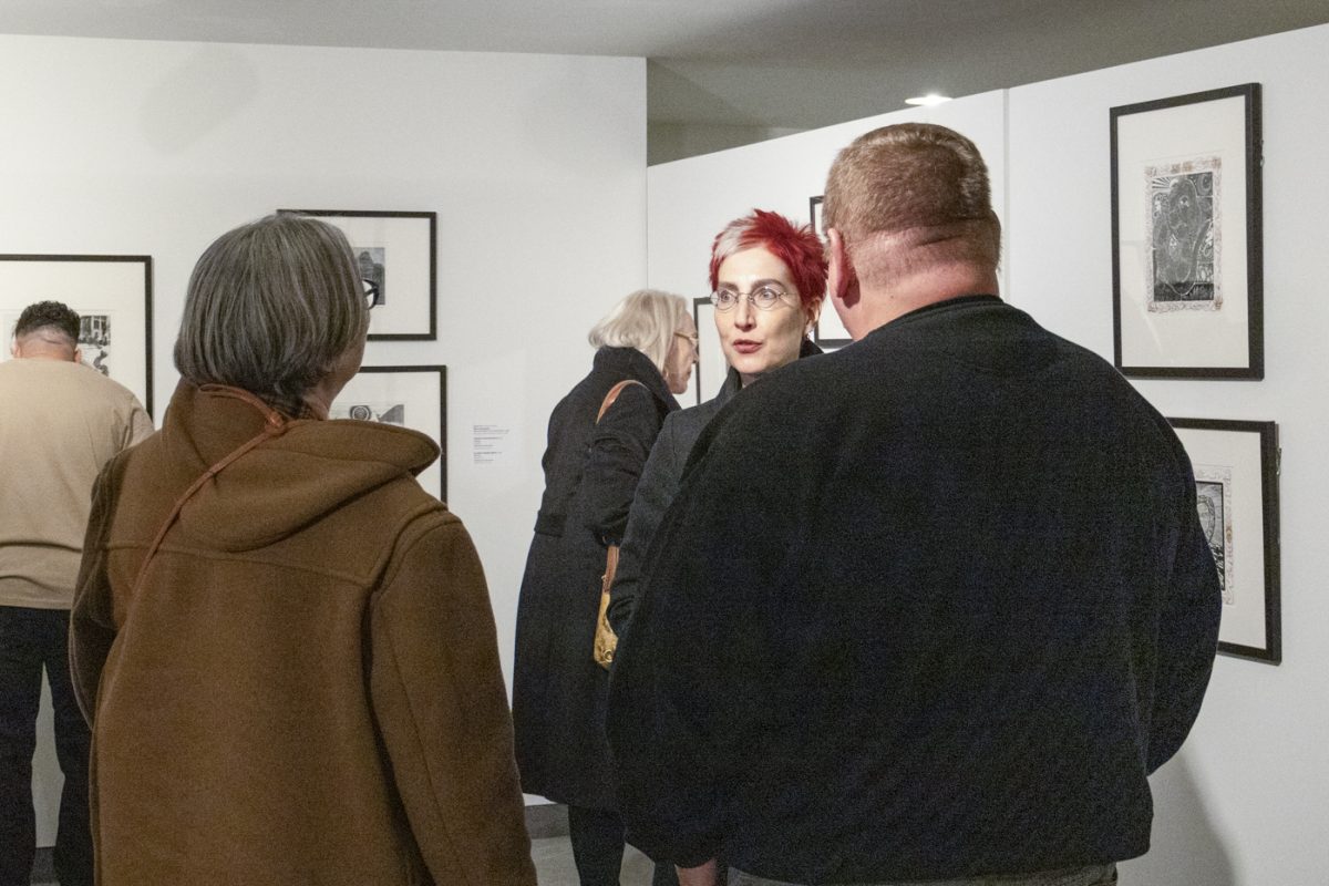 Marie Bukowski, the College of Fine Arts dean at Wichita State speaks with Jeff and Angela Pulaski at the Wichita Art Museum after Marco Hernandezs artist talk on Jan. 19.