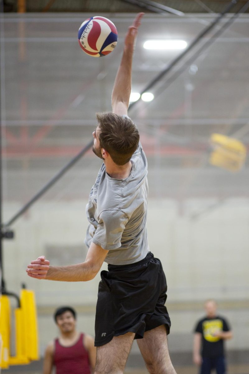 Xander Pickett, a member of the recreational mens volleyball team at Wichita State, prepares to volley the ball during practice on Jan. 30.