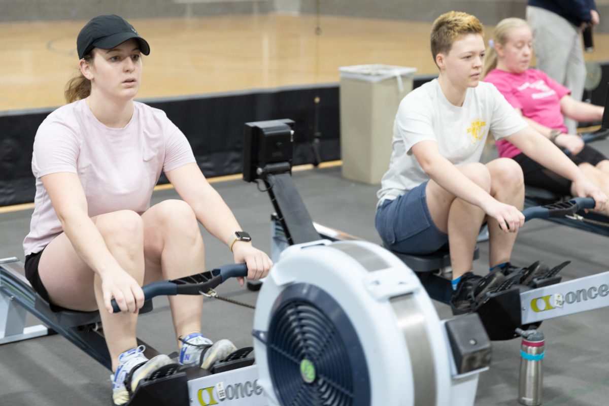 Maureen Wetta and Vivian Baughman use ergometer machines during rowing team practice. The Wichita State practices on ergometer machines in preparation for their spring season in the Heskett Center gymnasium.