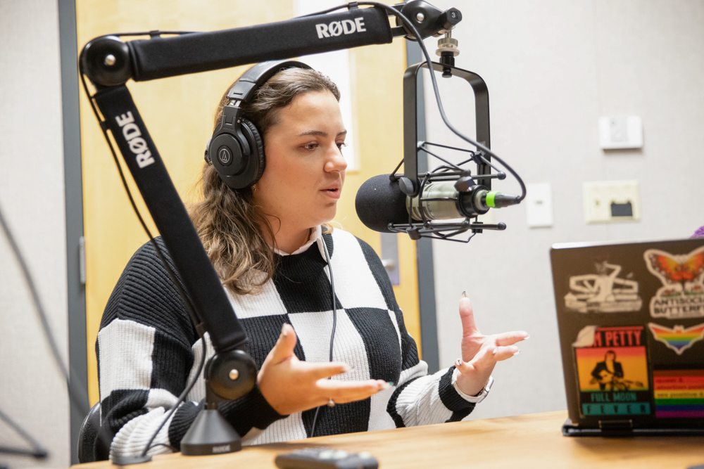 Shaybree Hanes, a junior graphic design major, discusses her logo design for The Mayflower Clinic on The Sunflower podcast. Hanes based her original design for the accessible health care clinic on the Mayflower ship.