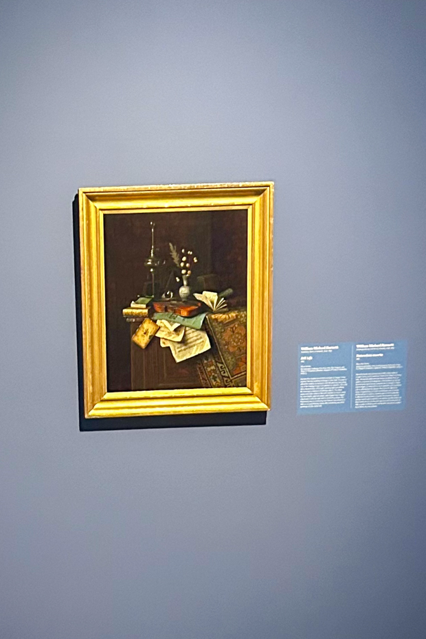 A view of “Still Life” by William Michael Harnett. The tattered book pages and chipped vase symbolizing contemporary obsession with the past.