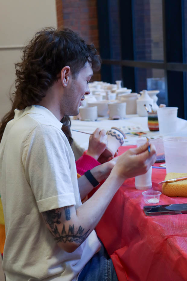 Javian Osterhout painting a clay vase on Feb. 14 at the Ulrich Museum of Art. The free Valentines Day event provided art supplies and snacks for those who came to learn the printmaking process. 