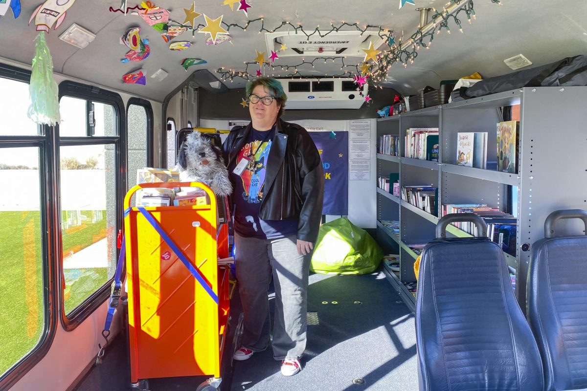 Racine Zackula, family literacy coordinator for the Wichita Public Library, poses inside the Wichita Public Librarys Book Bus. The inside of the bus holds various items, like puppets, bean bag chairs, and more.