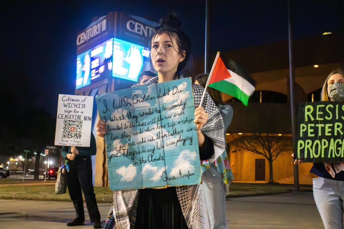 A protester displays a sign with a quote by Palestinian author and politician Ghassan Kanafani. I would love to go to Gaza and help those children that youre starving, she said in response to a heckler.