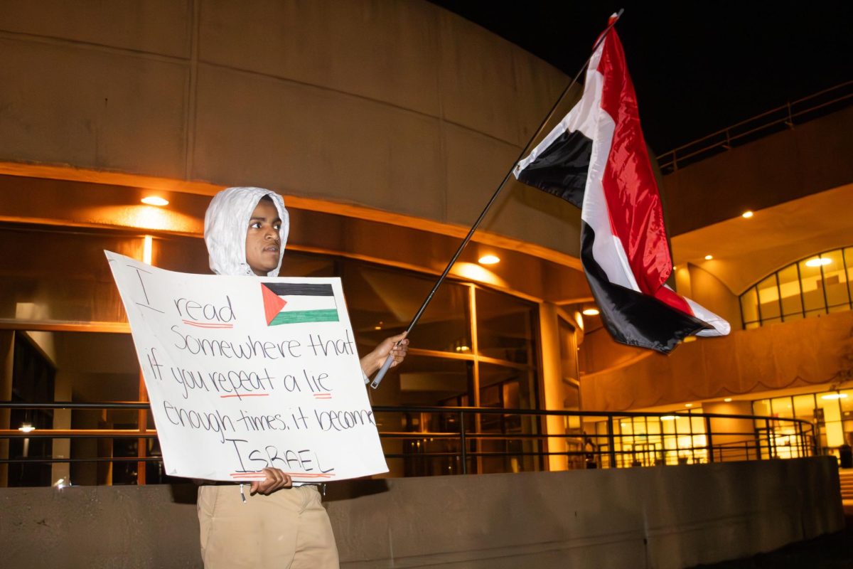 A 17-year-old protester waves the flag of Yemen while protesting outside of Century II on Monday, Feb. 26. Students and community members gathered at the convention center to call for a ceasefire in Gaza.