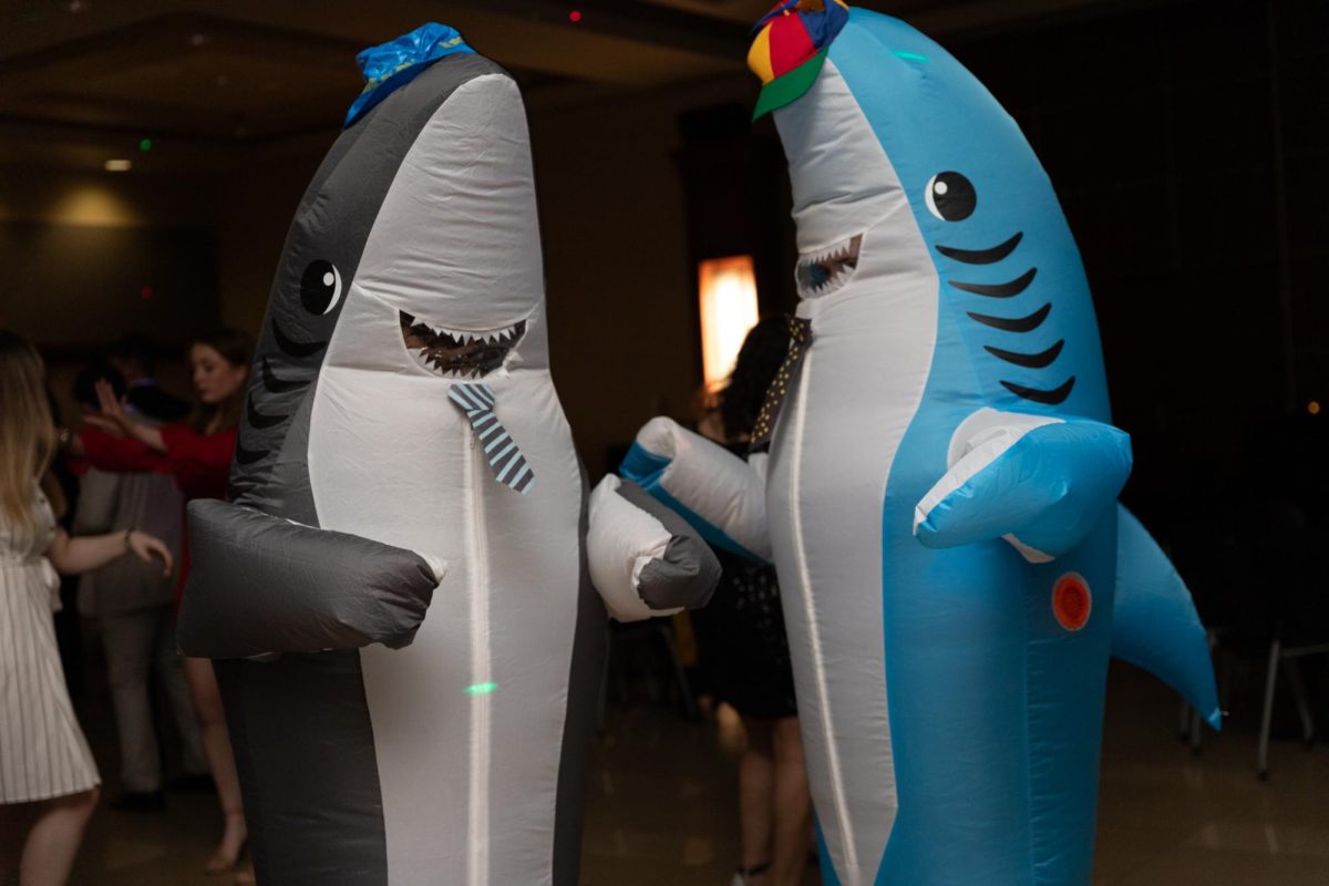 Two students in shark costumes adorned with hats and ties dance at the Fairmount Formal on Feb. 2. The annual Fairmount Formal, hosted by the Student Activities Council, was held in Beggs Ballroom and had music, a dance floor, refreshments, and a photo booth for students to enjoy.