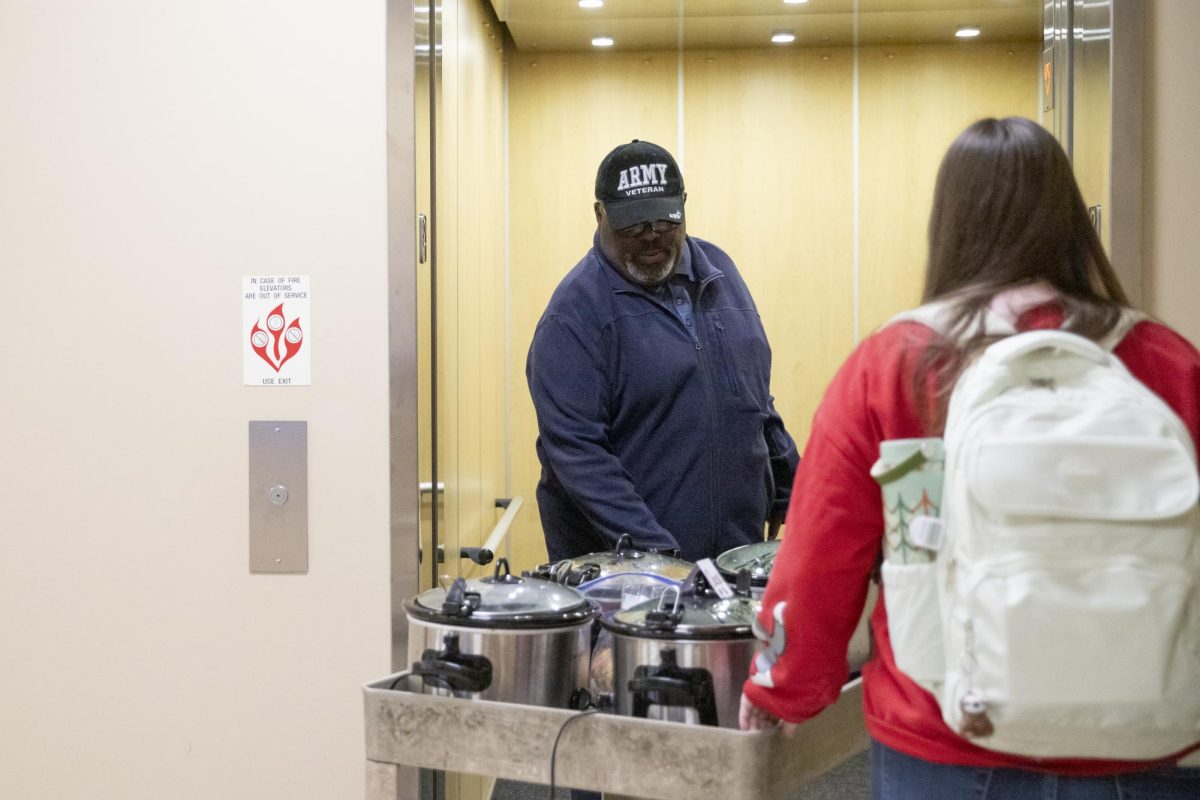 Larry Burks Sr. and Sierra Riley transport the chili for Veteran Students Organizations first event of the year from the second to first floor of the Rhatigan Student Center on Feb. 13. Students were able to get a bowl of chili for $3, with the proceeds going to the organization.