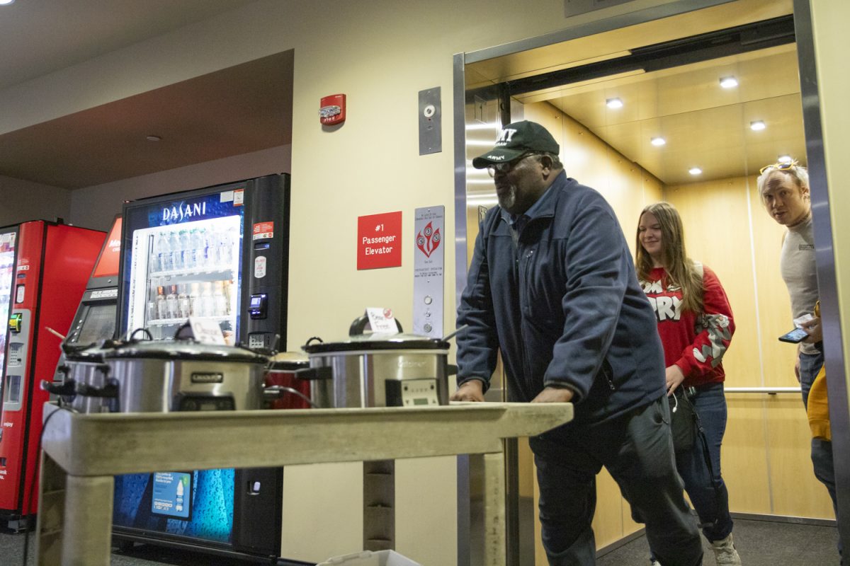 Larry Burks Sr., Sierra Riley and Jack Delmar transport the chili for Veteran Students Organizations first event of the year from the second to first floor of the Rhatigan Student Center on Feb. 13. The event was organizations first after a long hiatus.