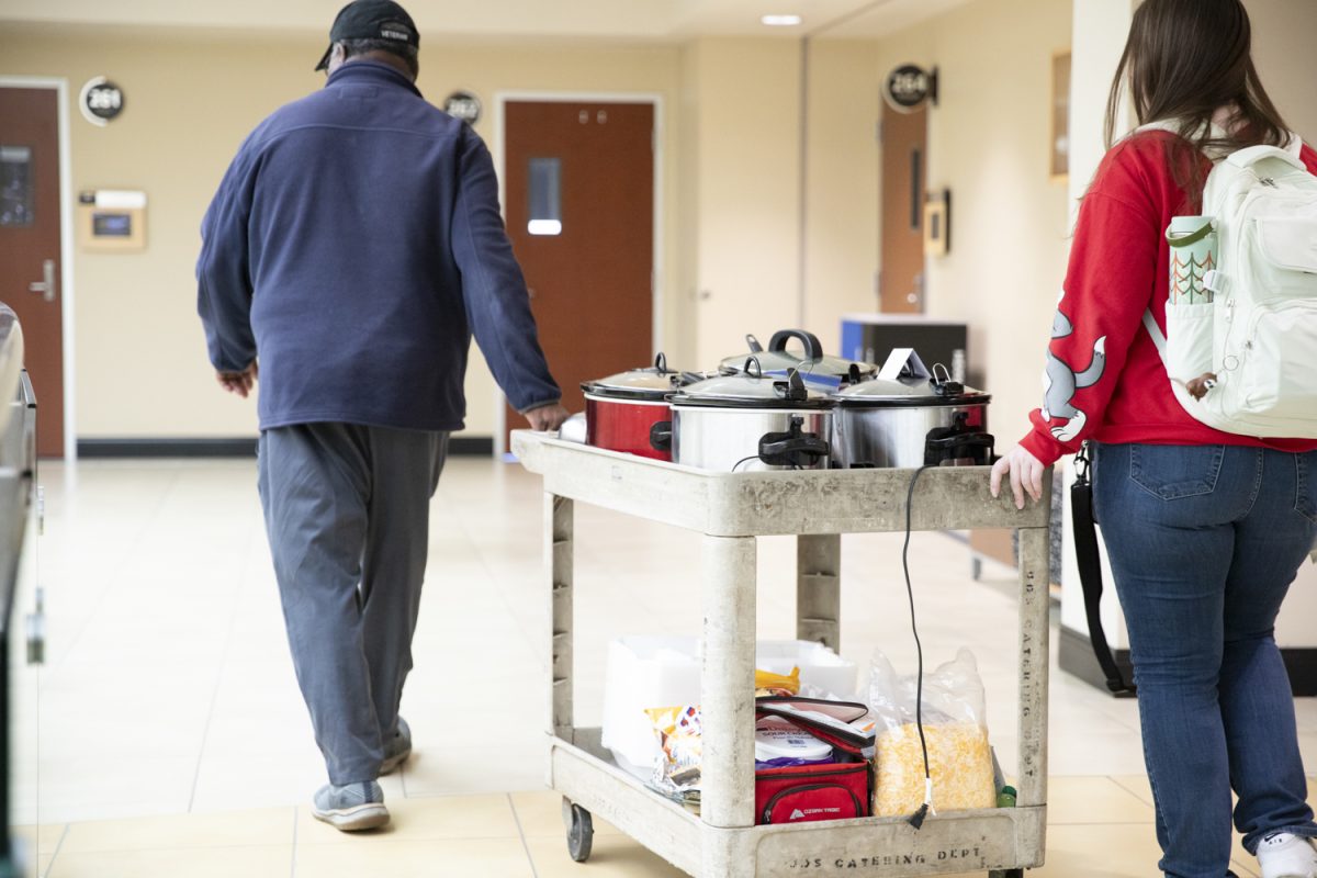 Larry Burks Sr. and Sierra Riley transport the chili for Veteran Students Organizations first event of the year from the second to first floor of the Rhatigan Student Center. Burks serves as the lead adviser of the organziation while Riley serves as the vice president.