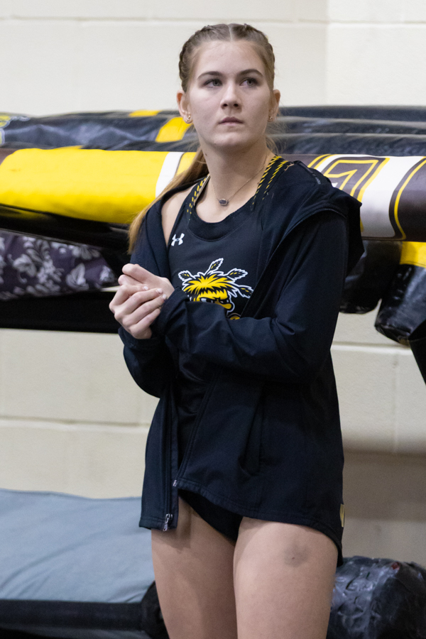 Redshirt pole vault freshman, Kinslee Stokely stands on the sideline waiting to compete in the pole vault at the Wilson Invitational in the Heskett Center on Jan. 26. Stokely placed 11th with a height of ten feet, four inches.