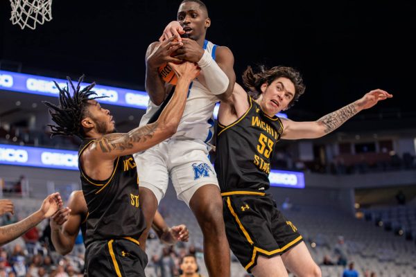 Colby Rogers and Bijan Cortes defend against Memphis player during the first half. Wichita State defeated the No. 5 team in the second round of the American Athletic Conference tournament.