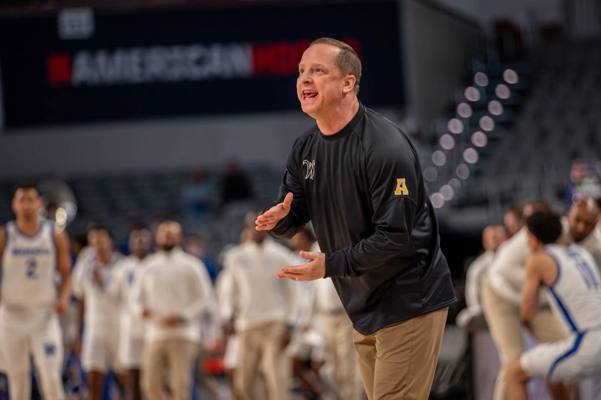 Head men's basketball coach Paul Mills yells to his players during the first half of the March 14 game against Memphis.