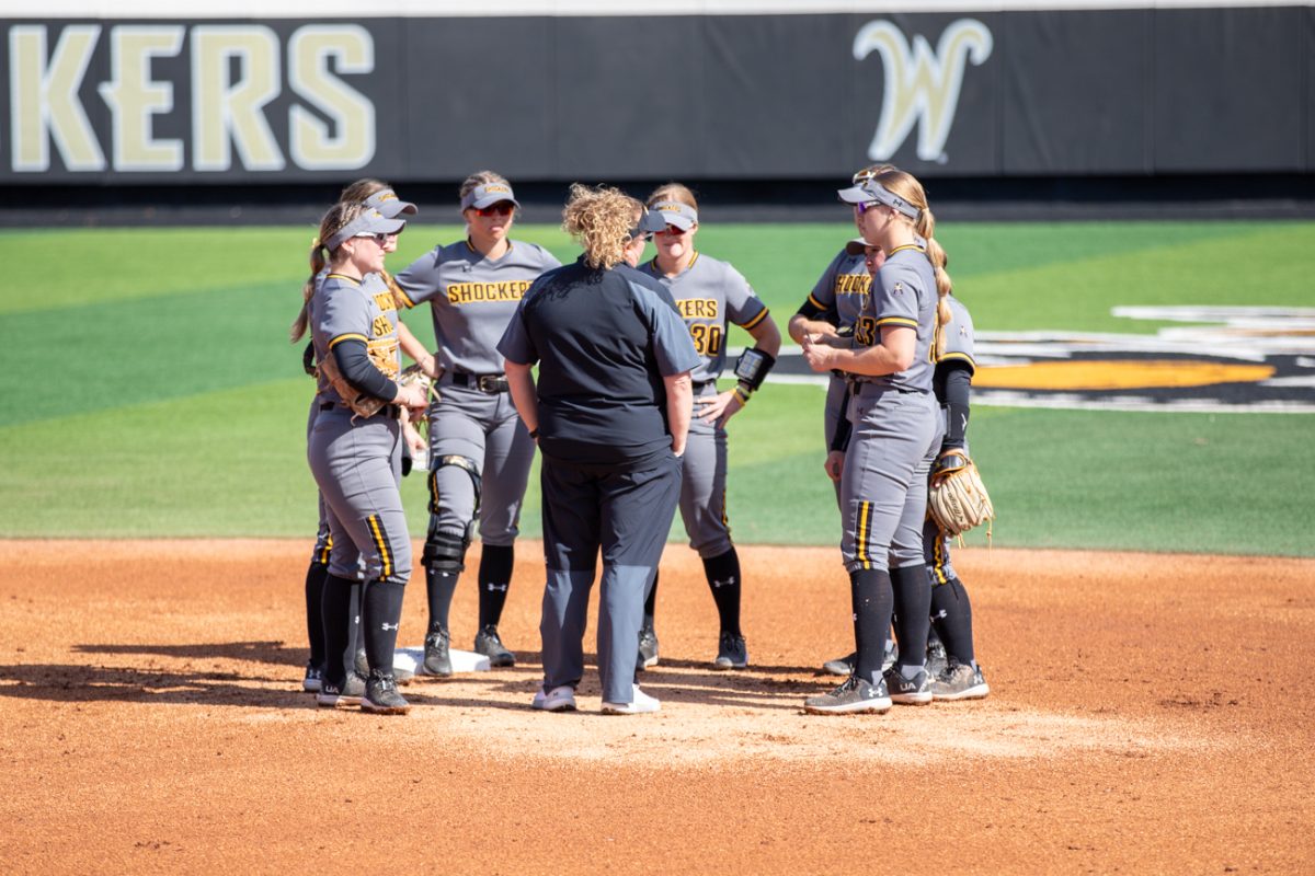 The Wichita State softball team gathers during a pause in the game against Florida Atlantic on March 10.