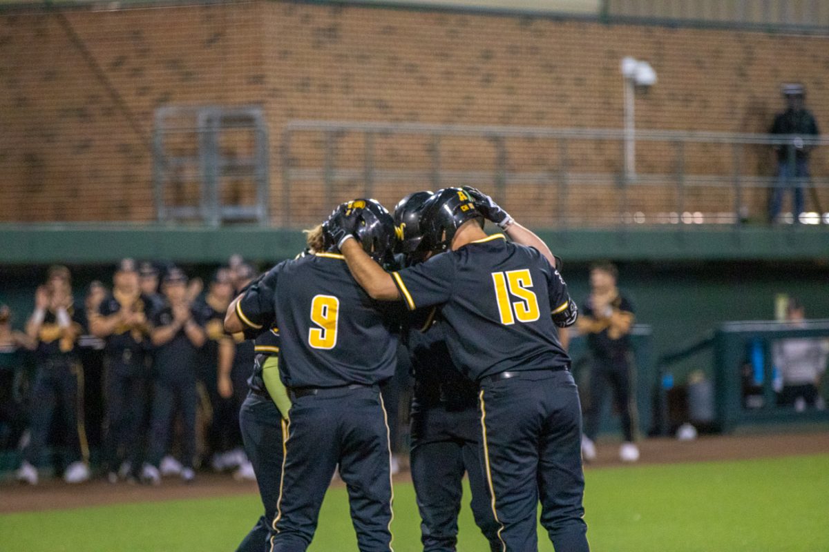 Wichita State baseball players touch helmets in a huddle during their game against Nebraska in Eck Stadium on March 12.