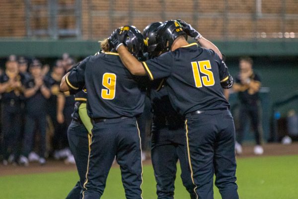 Wichita State baseball players touch helmets in a huddle during their game against Nebraska in Eck Stadium on March 12.