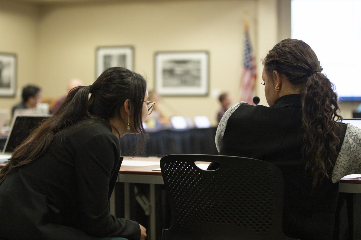 Jia Wen Wang and Sophie Martins speak on the side during Student Fees Committee deliberations on March 6. Wang serves as the student body treasure; Martins is the student body vice president.
