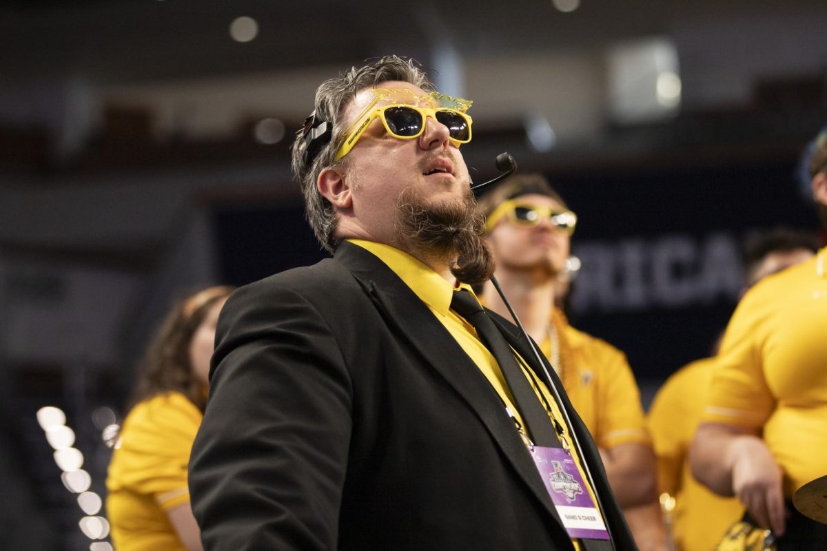 Lucas Hulett, assistant professor and director of athletic bands at WSU, watches the scoreboard during the game against Rice University on March 13. The Wichita State Sound Machine traveled to Fort Worth, Texas, to cheer on the mens basketball team.
