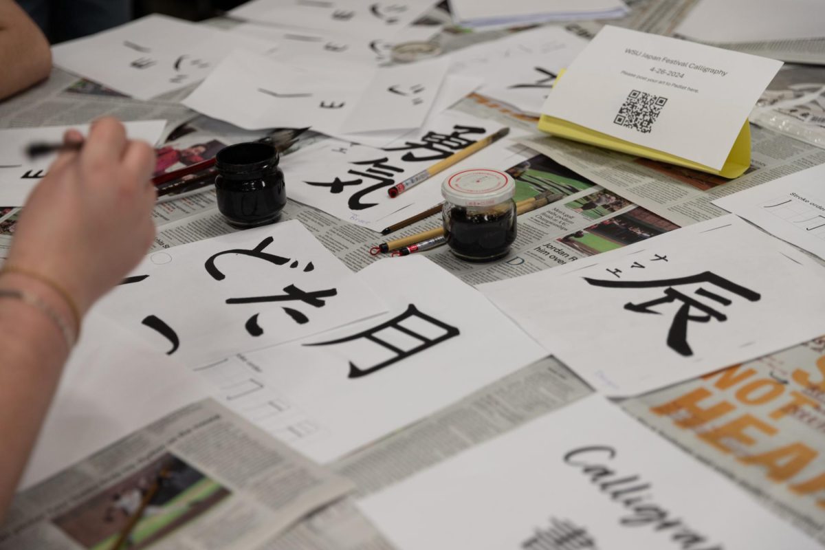 Students participate in a Japanese calligraphy station at the Japan Festival held by Asian Student Conference Dance and the Japanese Cultural Association. 