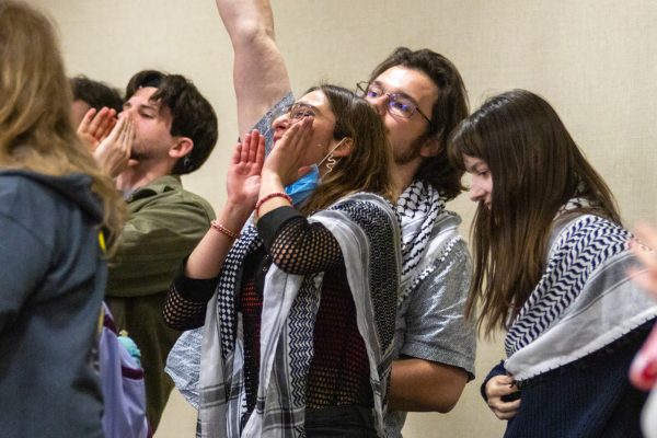 Members of Students for Justice in Palestine clap and cheer in support after the Ceasefire in Gaza resolution was passed by the Student Government Association. Free Palestine, members said, yelling in unison at the conclusion of the Senate meeting.