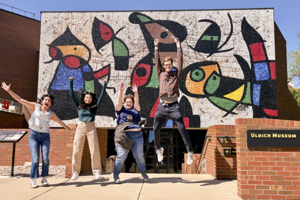 Lucia Suniga, Brisa Perez, Abby DeHaven and Gus Denneler jump for a photo in front of the Ulrich Museum of Art. The four were interns during the 2023-2024 academic year. (Photo courtesy of Jo Reinert)