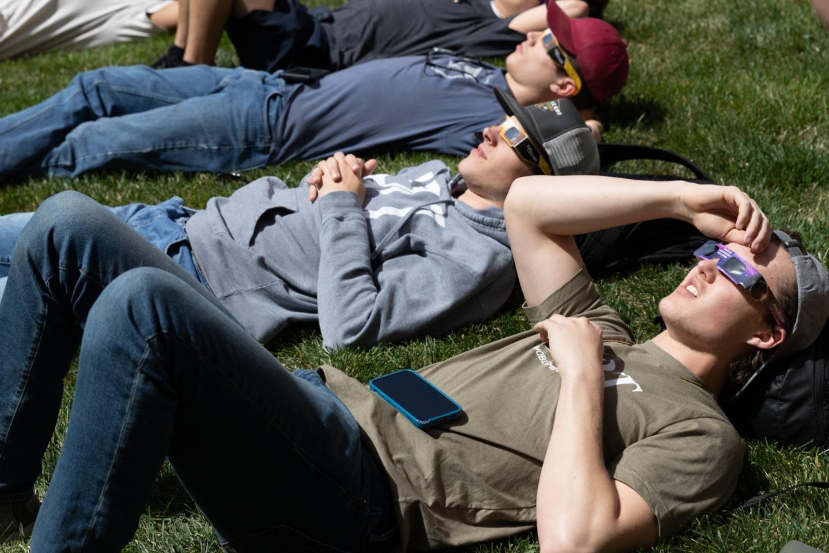 Students observe the solar eclipse on April 8 using glasses on the south side of Jabara Hall. Wichitans saw a partial solar eclipse, with 87.7% of the sun obscured by the moon.
