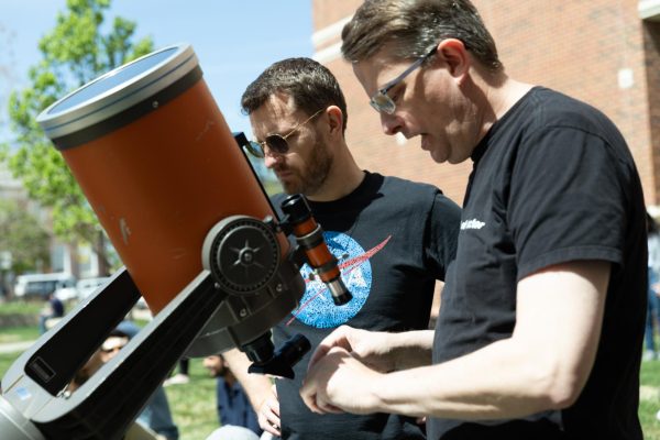 Physics professors Mathew Muether and Jason Ferguson set up telescope on lawn of Jabara Hall for observers to see the solar eclipse on April 8.