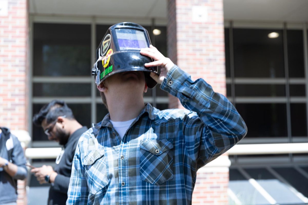 Engineering student Brett Sirkel views the solar eclipse through a welding mask on the Jabara Hall lawn.
