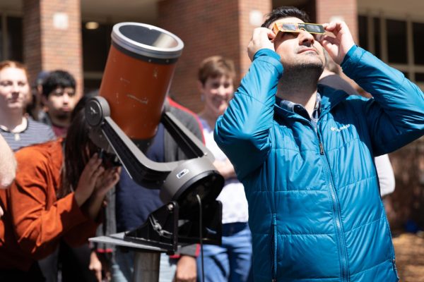 Students observe the solar eclipse on April 8 using glasses and a telescope on the south side of Jabara Hall. Wichitans saw a partial solar eclipse, with 87.7% of the sun obscured by the moon.